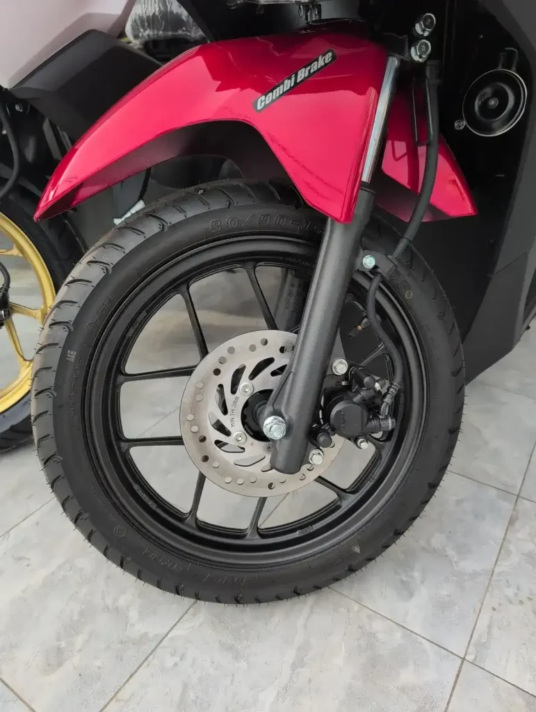 A disk brake (not drum brake) on the front wheel of a motorbike (scooter, motorcycle).