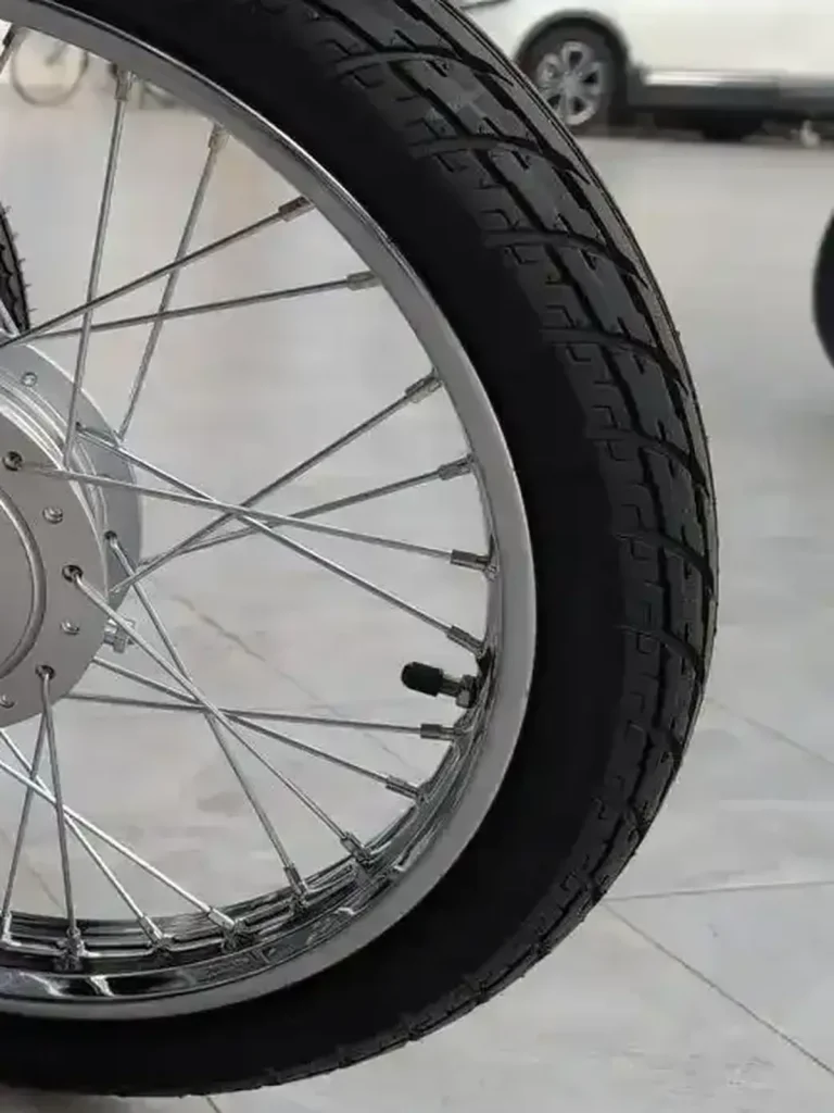 A tire on a motorbike with good tire tread. There is lots of tire tread remaining, and is safe to ride!