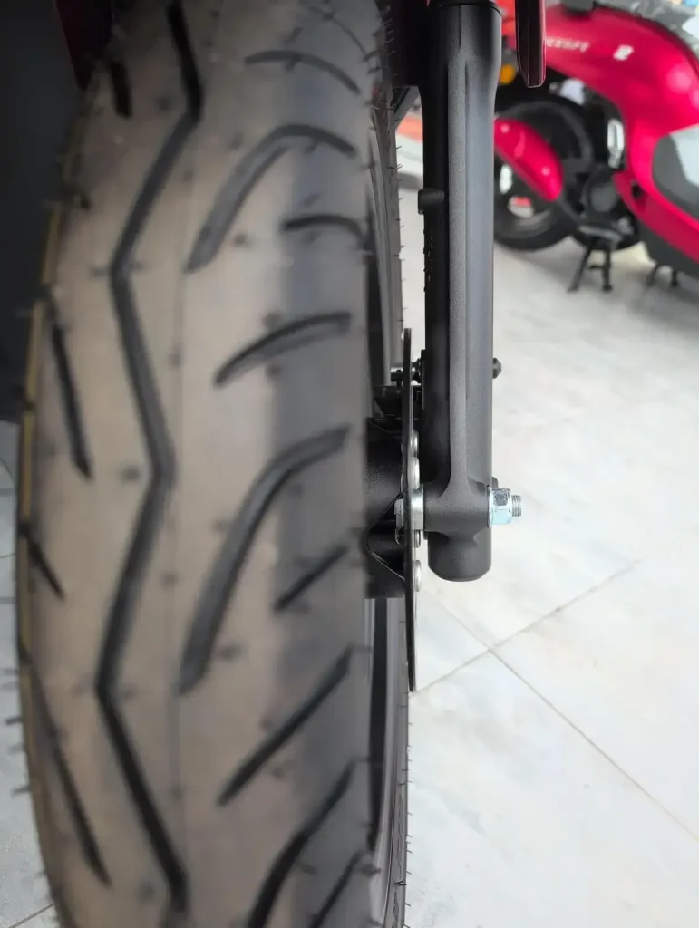 A tire on a motorbike with good tire tread. There is lots of tire tread remaining, and is safe to ride!