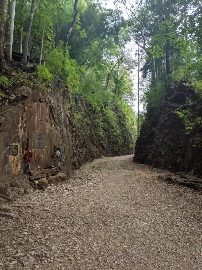 A view within the hellfire pass at it's most popular point where prisoners of war were force by Japanese soldiers to chisel through a large rock area and lay railway track. This rock area has steep and high walls, which are up to twenty-five meters deep and seventy-five meters long. On top of the rocky area is a cart on a track, which demonstrates how the prisoners carted-away the rock they chiseled out. Located in Kanchanaburi, Thailand
