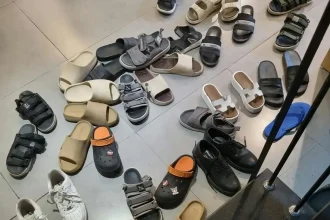 About thirty sandals at the entrance of a café. In Southeast Asia, it is common to take off your shoes (or sandals) before going inside some places. From this image it is clear that wearing sandals outnumbers wearing shoes in SE Asia.