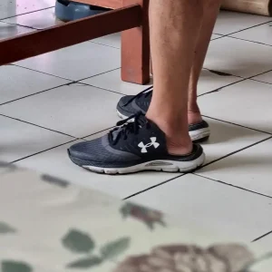 An image of the shoes on a man's feet in Thailand. The shoes have the heel cut off of them to turn them into slip-on sandals.