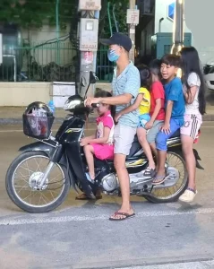 Six people riding on one motorbike. This includes one adult and five small children.