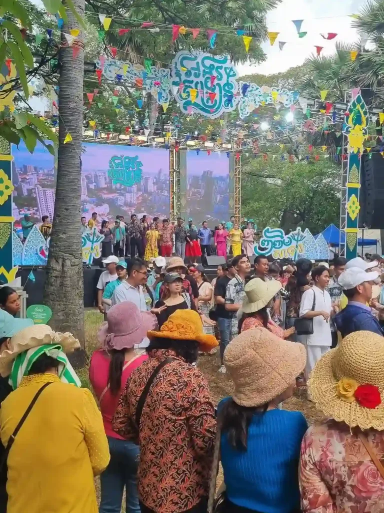 A local concert in a grassy area with trees with local Cambodians dancing. This is during the Songkran holiday festival in Cambodia. There is no water splashing here - everyone is dry - although this is holiday is mostly a continual water fight and splashing of water.