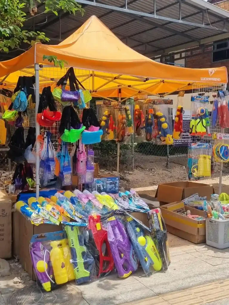 A canopy along the road selling Songkran festival gear such as water guns and water resistant pouches. This festival is essentially one massive water fight, and everyone gets soaking wet. This is located in Cambodia.