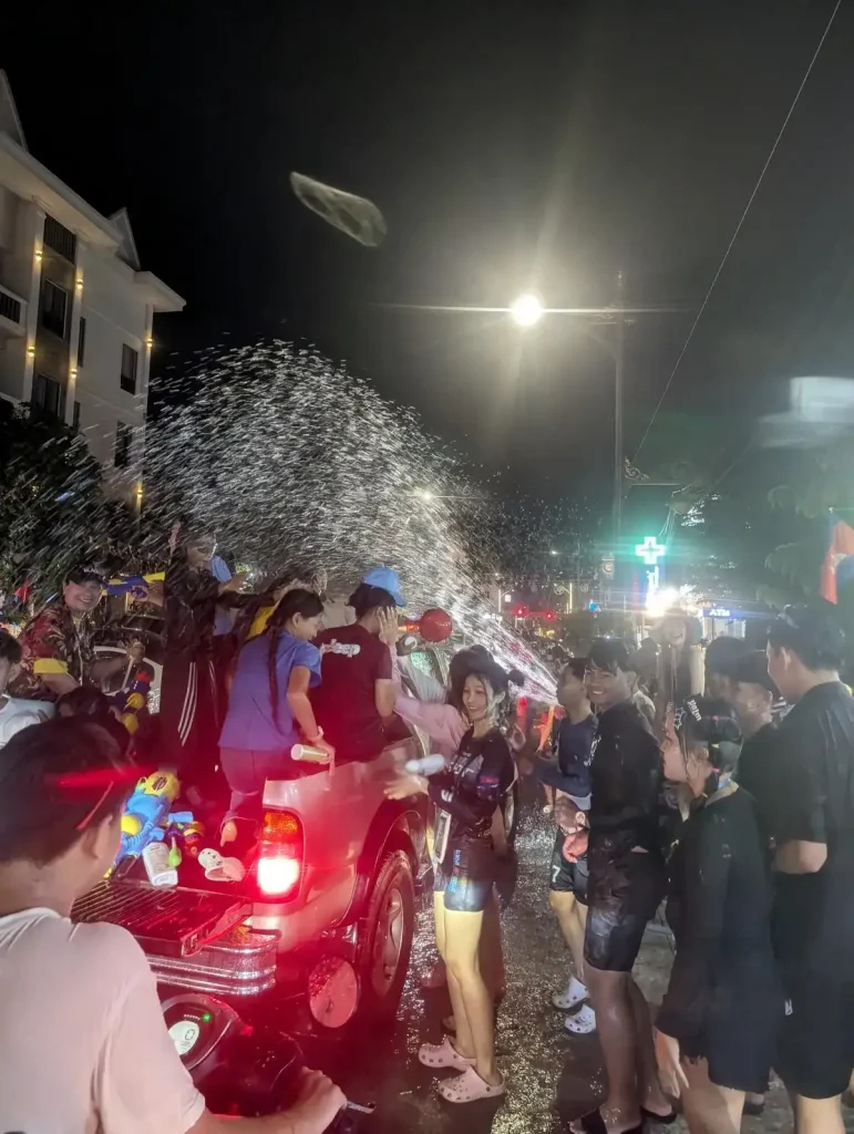 Songkran. A local road at night in Cambodia where everyone in the street (trucks, motorbikes, and pedestrians) are participating in the splashing of water for Songkran holiday festival. This festival is essentially one massive water fight, and everyone gets soaking wet.