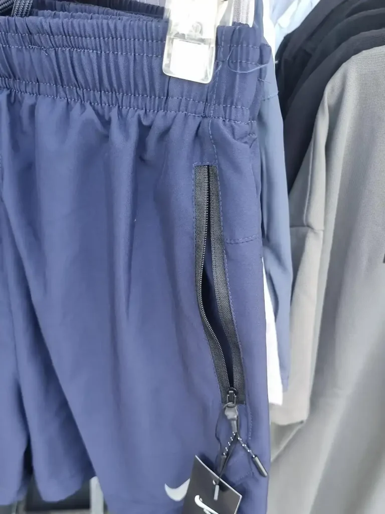 A pair of [knock-off] Nike sport shorts that have zipper pockets. Having a zipper pocket prevents loosing things. These are for sale at a shop in Southeast Asia.